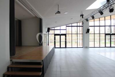 Cuisine professionnelle avec plans de travail en inox, équipements de cuisson, éviers et carrelage mural gris.