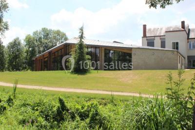 Cuisine professionnelle avec plans de travail en inox, équipements de cuisson, éviers et carrelage mural gris.