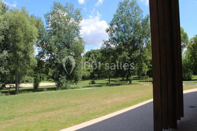 Cuisine professionnelle avec plans de travail en inox, équipements de cuisson, éviers et carrelage mural gris.