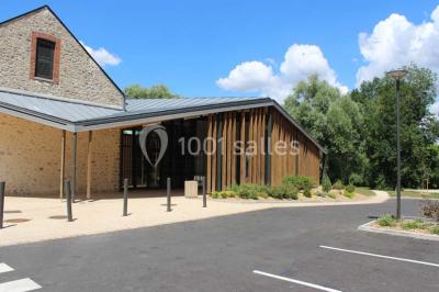 Cuisine professionnelle avec plans de travail en inox, équipements de cuisson, éviers et carrelage mural gris.