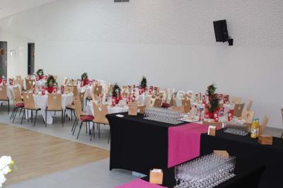 Cuisine professionnelle avec plans de travail en inox, équipements de cuisson, éviers et carrelage mural gris.