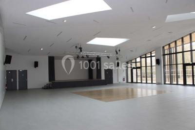 Cuisine professionnelle avec plans de travail en inox, équipements de cuisson, éviers et carrelage mural gris.