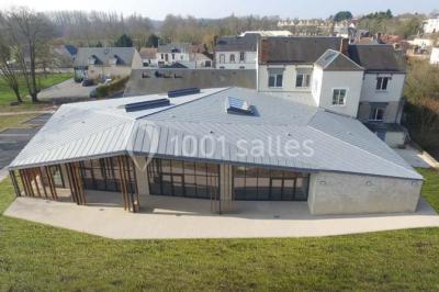 Cuisine professionnelle avec plans de travail en inox, équipements de cuisson, éviers et carrelage mural gris.