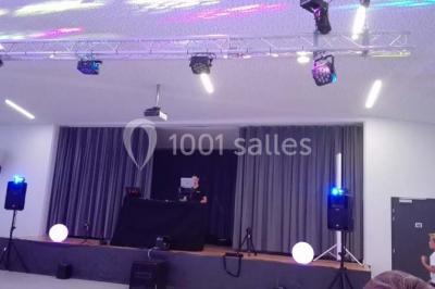 Cuisine professionnelle avec plans de travail en inox, équipements de cuisson, éviers et carrelage mural gris.