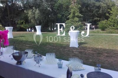 Cuisine professionnelle avec plans de travail en inox, équipements de cuisson, éviers et carrelage mural gris.