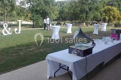 Cuisine professionnelle avec plans de travail en inox, équipements de cuisson, éviers et carrelage mural gris.