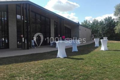 Cuisine professionnelle avec plans de travail en inox, équipements de cuisson, éviers et carrelage mural gris.