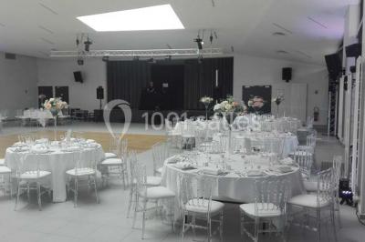 Cuisine professionnelle avec plans de travail en inox, équipements de cuisson, éviers et carrelage mural gris.