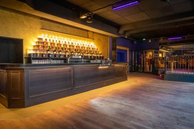 Intérieur d'un restaurant avec des tables, des chaises élégantes, un escalier en colimaçon et une ambiance chaleureuse.