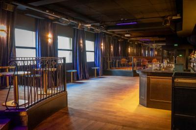 Intérieur d'un restaurant avec des tables, des chaises élégantes, un escalier en colimaçon et une ambiance chaleureuse.