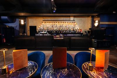 Intérieur d'un restaurant avec des tables, des chaises élégantes, un escalier en colimaçon et une ambiance chaleureuse.