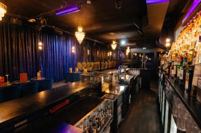 Intérieur d'un restaurant avec des tables, des chaises élégantes, un escalier en colimaçon et une ambiance chaleureuse.