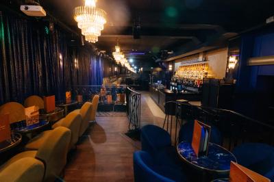 Intérieur d'un restaurant avec des tables, des chaises élégantes, un escalier en colimaçon et une ambiance chaleureuse.