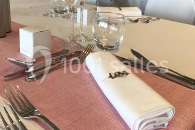 Vue d'une côte avec des falaises, des bâtiments en bord de mer et un ciel partiellement nuageux au crépuscule.