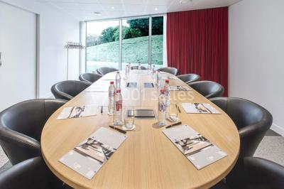 Bâtiment circulaire moderne illuminé la nuit, avec un chemin éclairé et des rampes décorées de lumières.