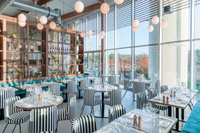 Bâtiment circulaire moderne illuminé la nuit, avec un chemin éclairé et des rampes décorées de lumières.