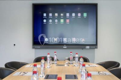 Bâtiment circulaire moderne illuminé la nuit, avec un chemin éclairé et des rampes décorées de lumières.