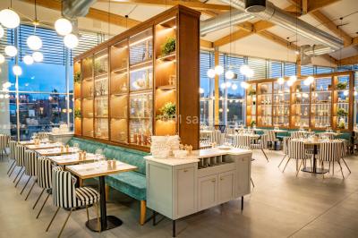 Bâtiment circulaire moderne illuminé la nuit, avec un chemin éclairé et des rampes décorées de lumières.