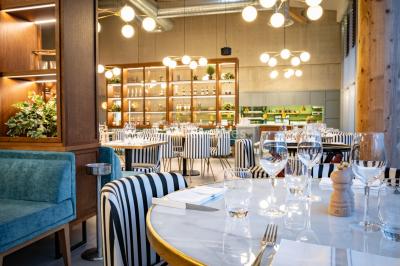 Bâtiment circulaire moderne illuminé la nuit, avec un chemin éclairé et des rampes décorées de lumières.