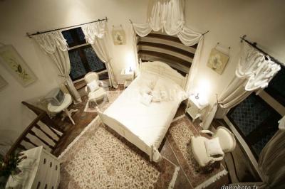 Un couple en tenue de mariage marche dans une allée extérieure décorée, entourée de chaises et de pétales de fleurs.