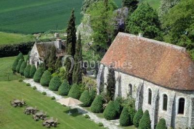 Un couple en tenue de mariage marche dans une allée extérieure décorée, entourée de chaises et de pétales de fleurs.