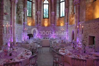 Un couple en tenue de mariage marche dans une allée extérieure décorée, entourée de chaises et de pétales de fleurs.