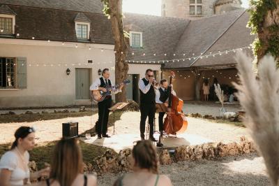 Un couple en tenue de mariage marche dans une allée extérieure décorée, entourée de chaises et de pétales de fleurs.