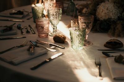 Un couple en tenue de mariage marche dans une allée extérieure décorée, entourée de chaises et de pétales de fleurs.