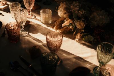 Un couple en tenue de mariage marche dans une allée extérieure décorée, entourée de chaises et de pétales de fleurs.