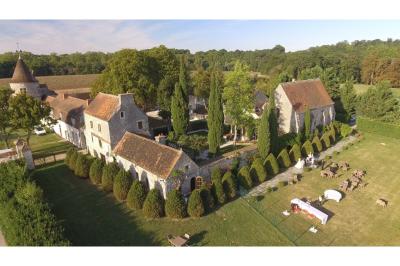 Un couple en tenue de mariage marche dans une allée extérieure décorée, entourée de chaises et de pétales de fleurs.