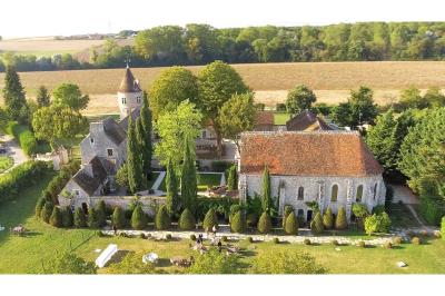 Un couple en tenue de mariage marche dans une allée extérieure décorée, entourée de chaises et de pétales de fleurs.