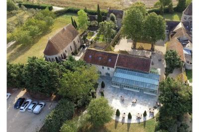 Un couple en tenue de mariage marche dans une allée extérieure décorée, entourée de chaises et de pétales de fleurs.