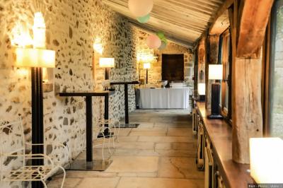 Un couple en tenue de mariage marche dans une allée extérieure décorée, entourée de chaises et de pétales de fleurs.