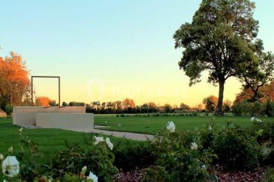 Vue aérienne d'une fête nocturne en extérieur avec éclairages violets, scène musicale et invités rassemblés.