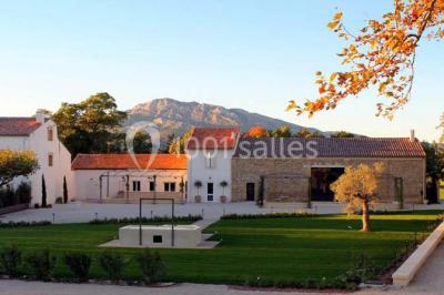 Vue aérienne d'une fête nocturne en extérieur avec éclairages violets, scène musicale et invités rassemblés.
