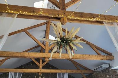 Vue aérienne d'une fête nocturne en extérieur avec éclairages violets, scène musicale et invités rassemblés.