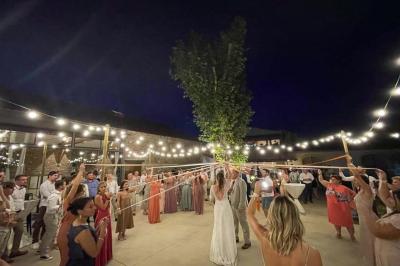 Vue aérienne d'une fête nocturne en extérieur avec éclairages violets, scène musicale et invités rassemblés.