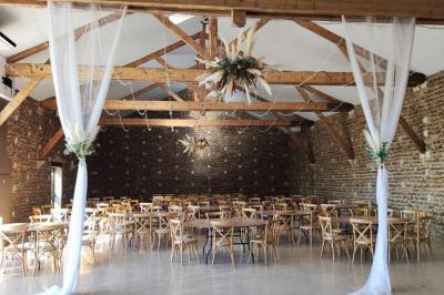 Vue aérienne d'une fête nocturne en extérieur avec éclairages violets, scène musicale et invités rassemblés.