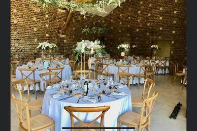 Vue aérienne d'une fête nocturne en extérieur avec éclairages violets, scène musicale et invités rassemblés.