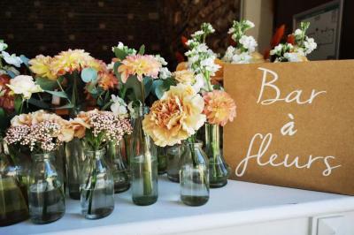 Vue aérienne d'une fête nocturne en extérieur avec éclairages violets, scène musicale et invités rassemblés.