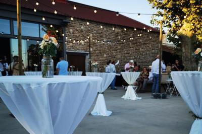 Vue aérienne d'une fête nocturne en extérieur avec éclairages violets, scène musicale et invités rassemblés.
