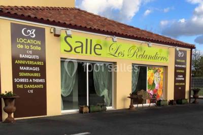 Salle de réception décorée avec des tables dressées, nappes blanches, chaises ornées de nœuds violets et centres de table…