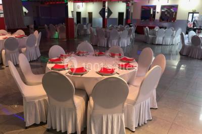 Cuisine professionnelle équipée avec lave-vaisselle industriel, réfrigérateur, plan de travail et cuisinière en inox.