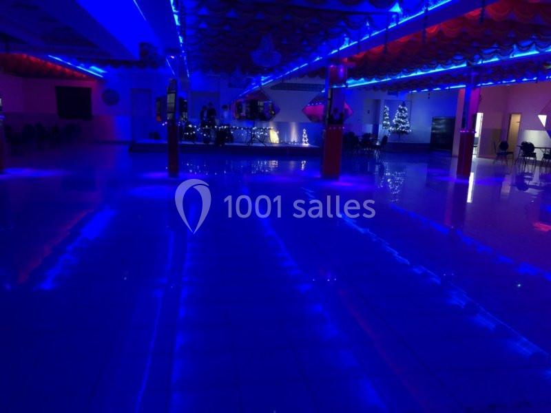 Salle de réception vide éclairée par des lumières bleues avec des décorations lumineuses en arrière-plan.