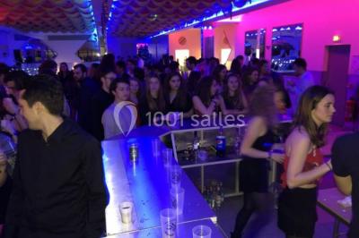 Cuisine professionnelle équipée avec lave-vaisselle industriel, réfrigérateur, plan de travail et cuisinière en inox.