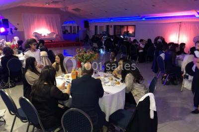 Cuisine professionnelle équipée avec lave-vaisselle industriel, réfrigérateur, plan de travail et cuisinière en inox.