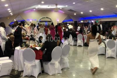 Cuisine professionnelle équipée avec lave-vaisselle industriel, réfrigérateur, plan de travail et cuisinière en inox.