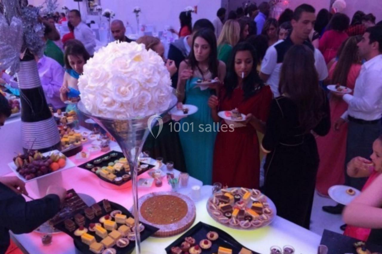 Des invités se servent à un buffet varié lors d'un événement, avec des desserts et des décorations élégantes.