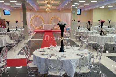 Cuisine professionnelle équipée avec lave-vaisselle industriel, réfrigérateur, plan de travail et cuisinière en inox.