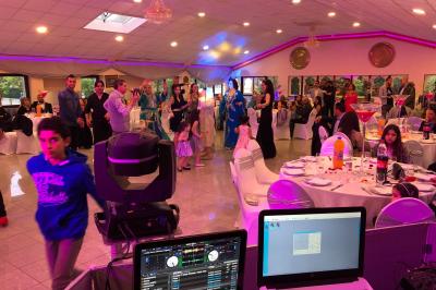 Cuisine professionnelle équipée avec lave-vaisselle industriel, réfrigérateur, plan de travail et cuisinière en inox.